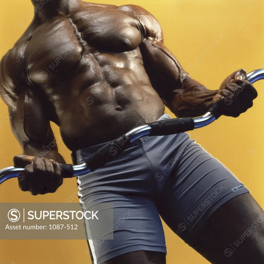 Mid section view of a man exercising with a barbell