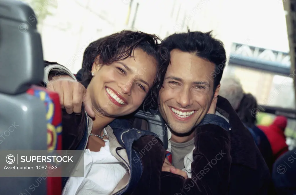 Portrait of a young couple smiling on a bus