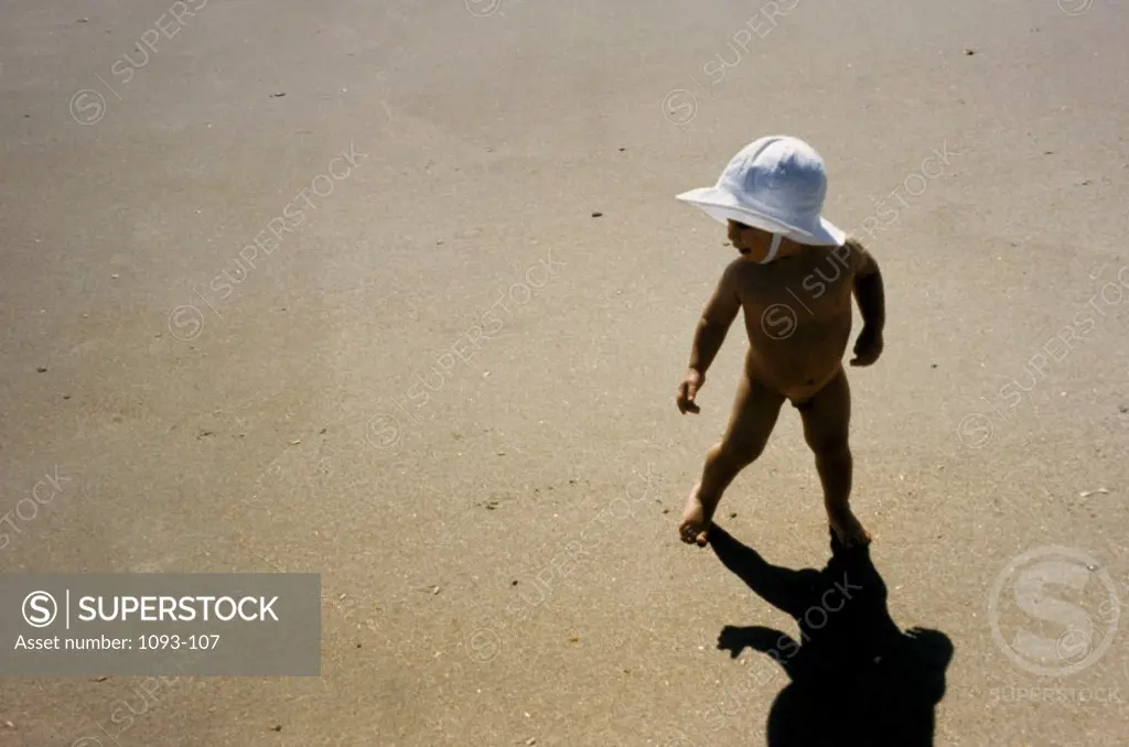 High angle view of naked baby boy running on the beach