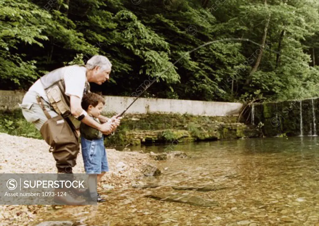 Senior man teaching a child how to fish