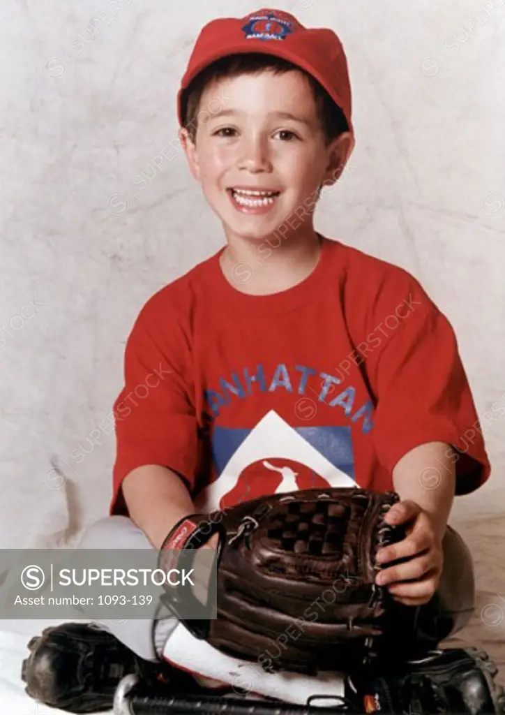 Portrait of a boy wearing a baseball glove smiling