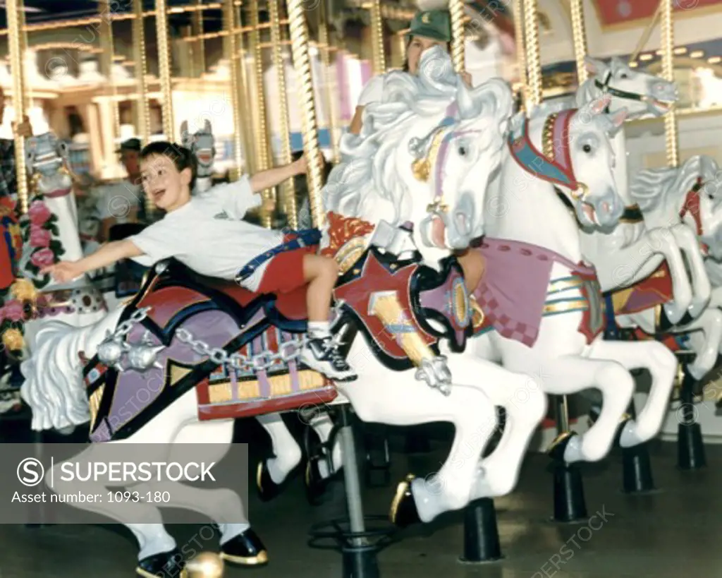 Boy riding a carousel horse