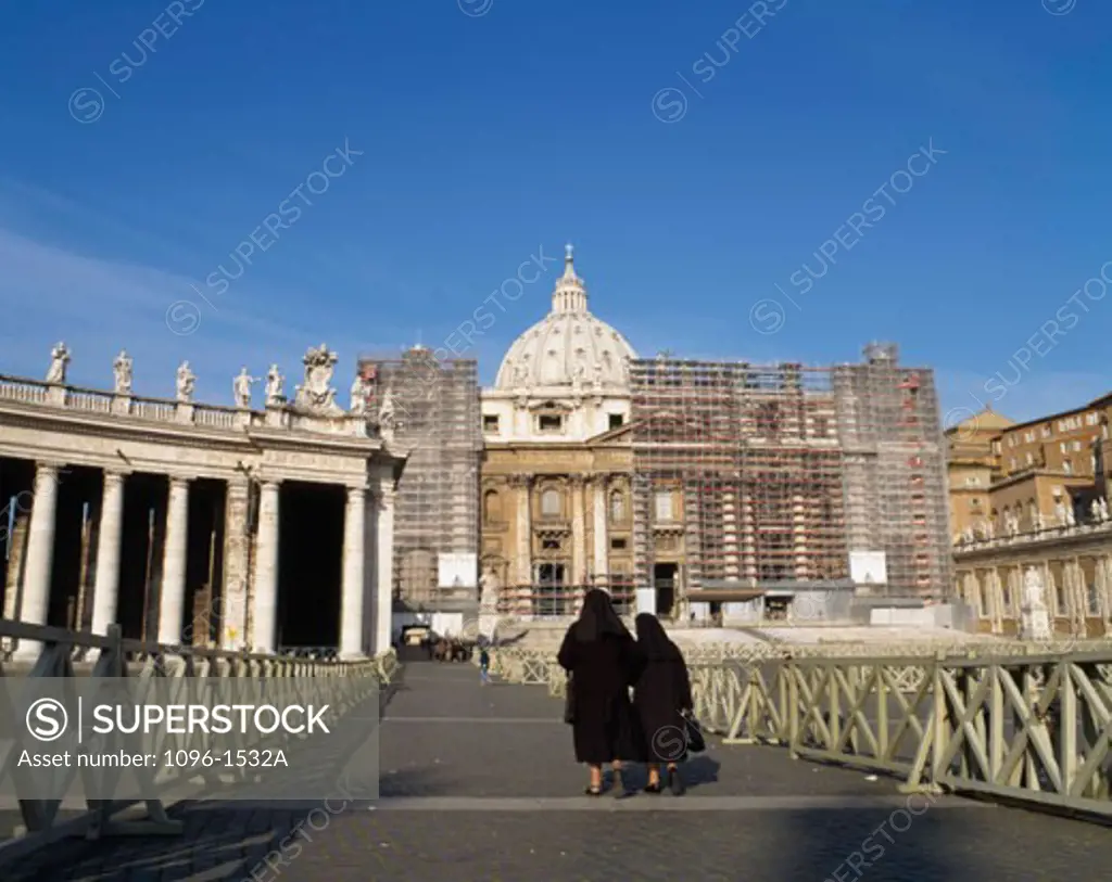 Rear view of two women walking in front of a basilica, St. Peter's Basilica, St. Peter's Square, Vatican City