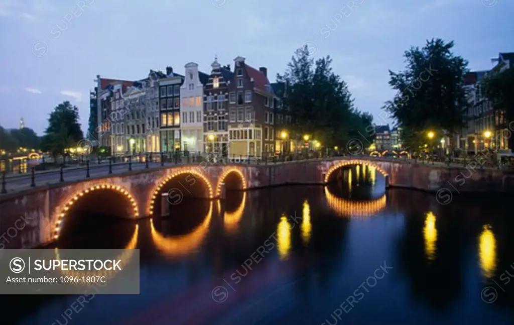 Arch bridge lit up at dusk, Amsterdam, Netherlands