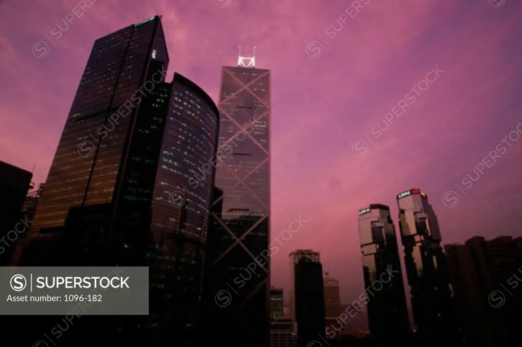 Low angle view of skyscrapers lit up at dusk, Citibank, Bank of China Tower, Lippo Centre, Hong Kong, China