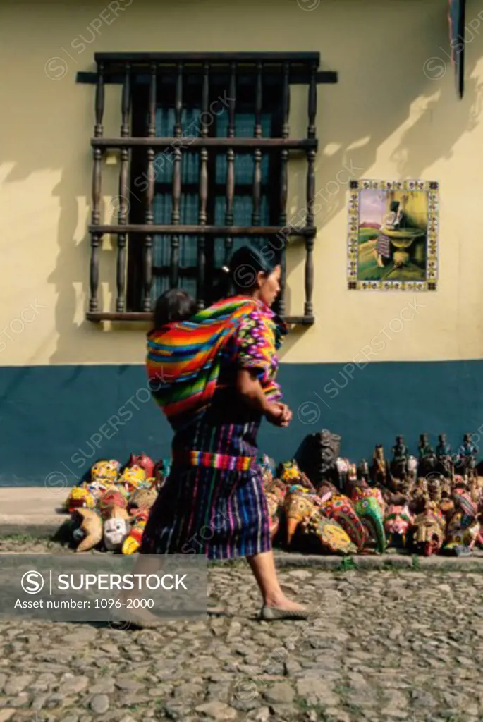 Mid adult woman carrying her baby on her back, Chichicastenango, Guatemala
