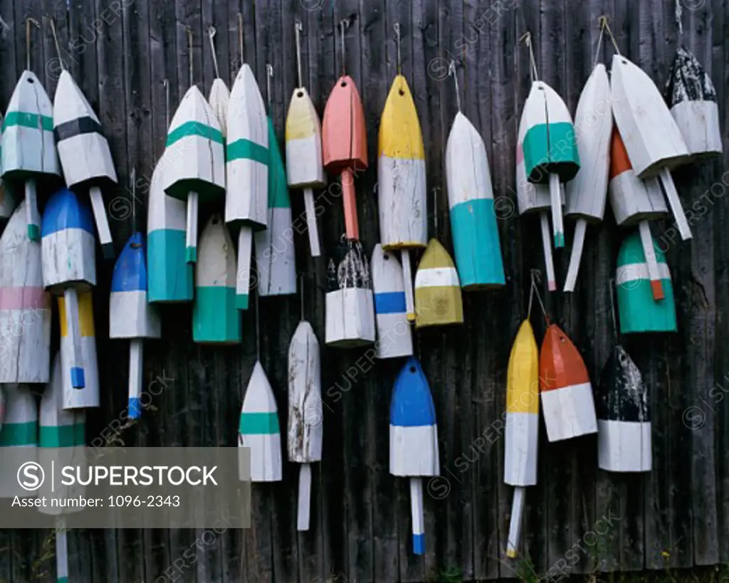 Close-up of lobster buoys hanging on a fence