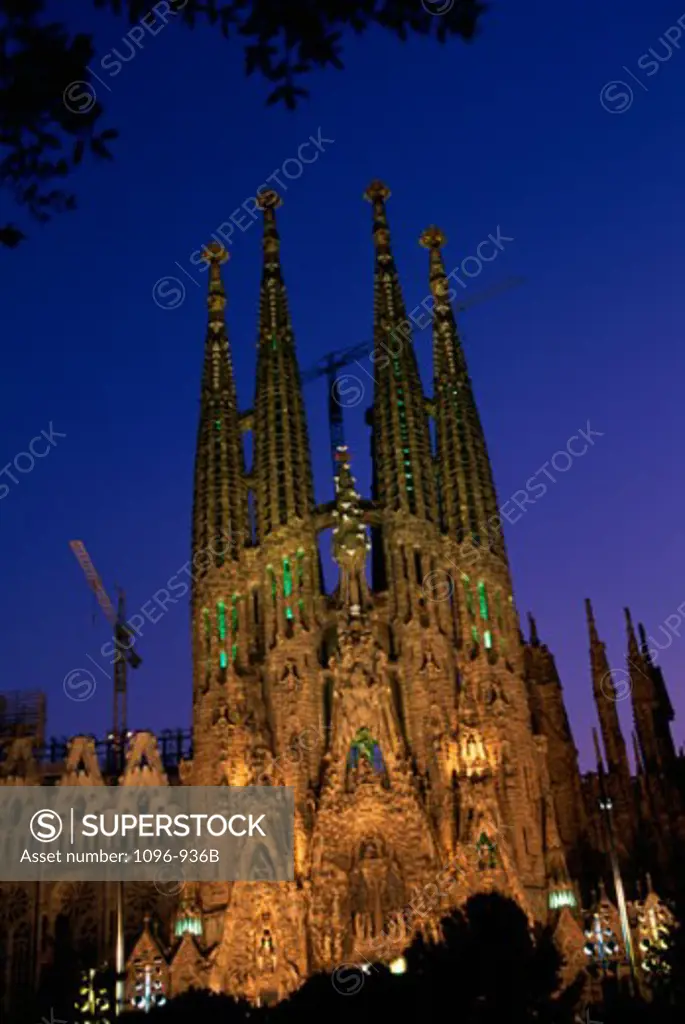 Low angle view of a basilica lit up at dusk, Sagrada Familia, Barcelona, Spain