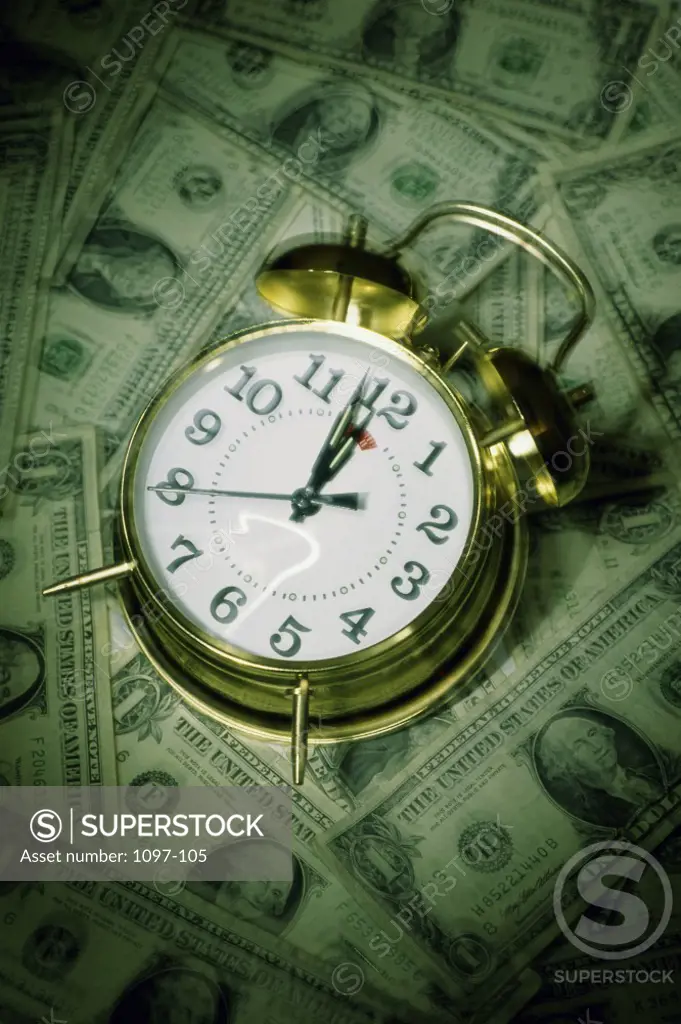 Close-up of an alarm clock on American dollar bills