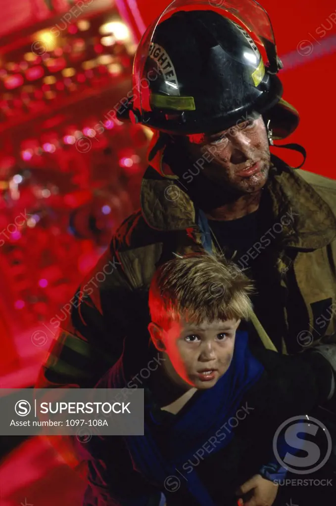 Close-up of a firefighter carrying a boy