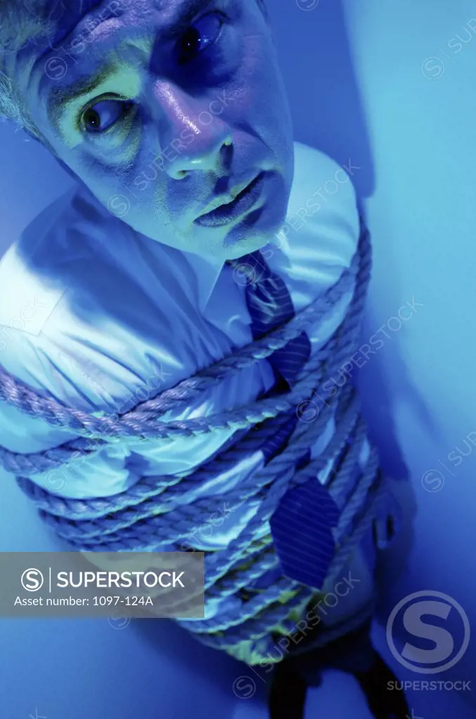 High angle view of a businessman bound in rope