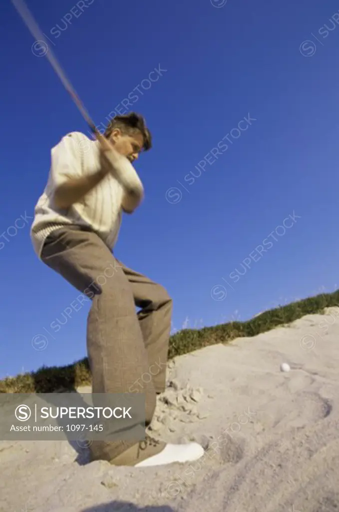 Low angle view of a mid adult man swinging a golf club