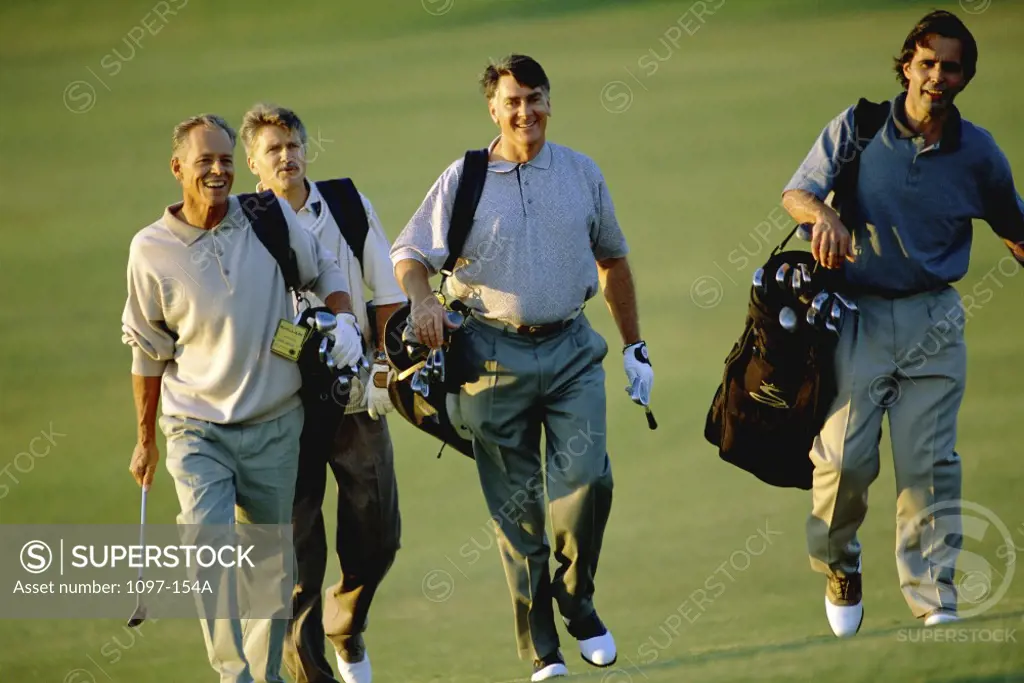 Four men walking on a golf course