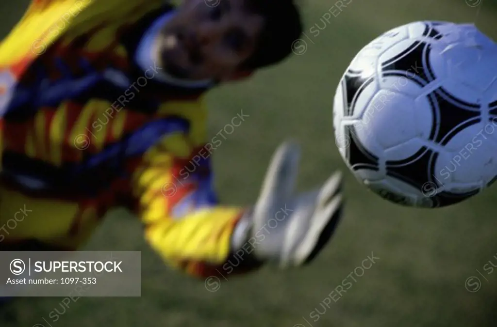 Goalie attempting to stop a soccer ball