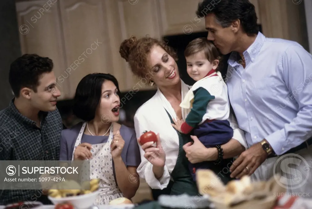 Family standing in a kitchen and smiling