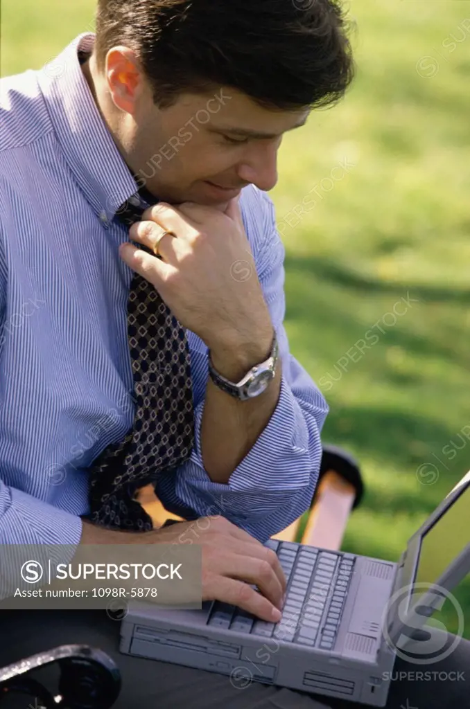 Side profile of a businessman working on a laptop