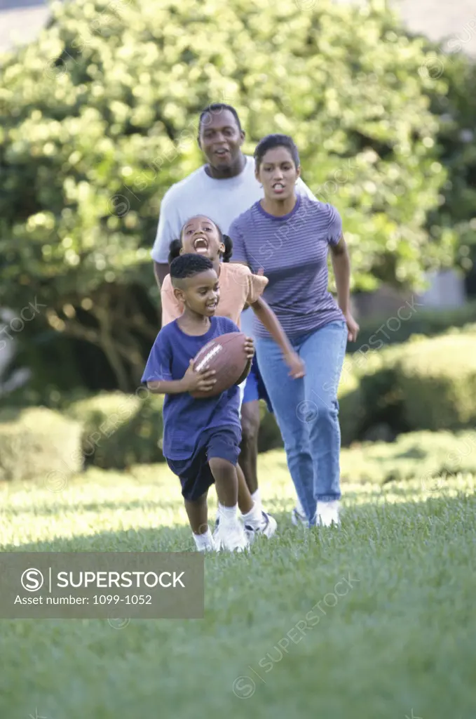 Parents playing football with their son and daughter