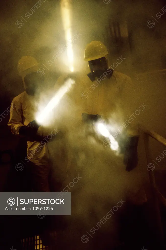 Two workers holding flashlights