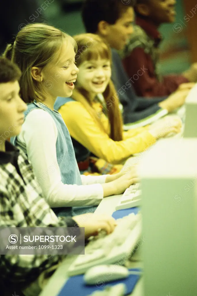 Side profile of a group of children in front of computers