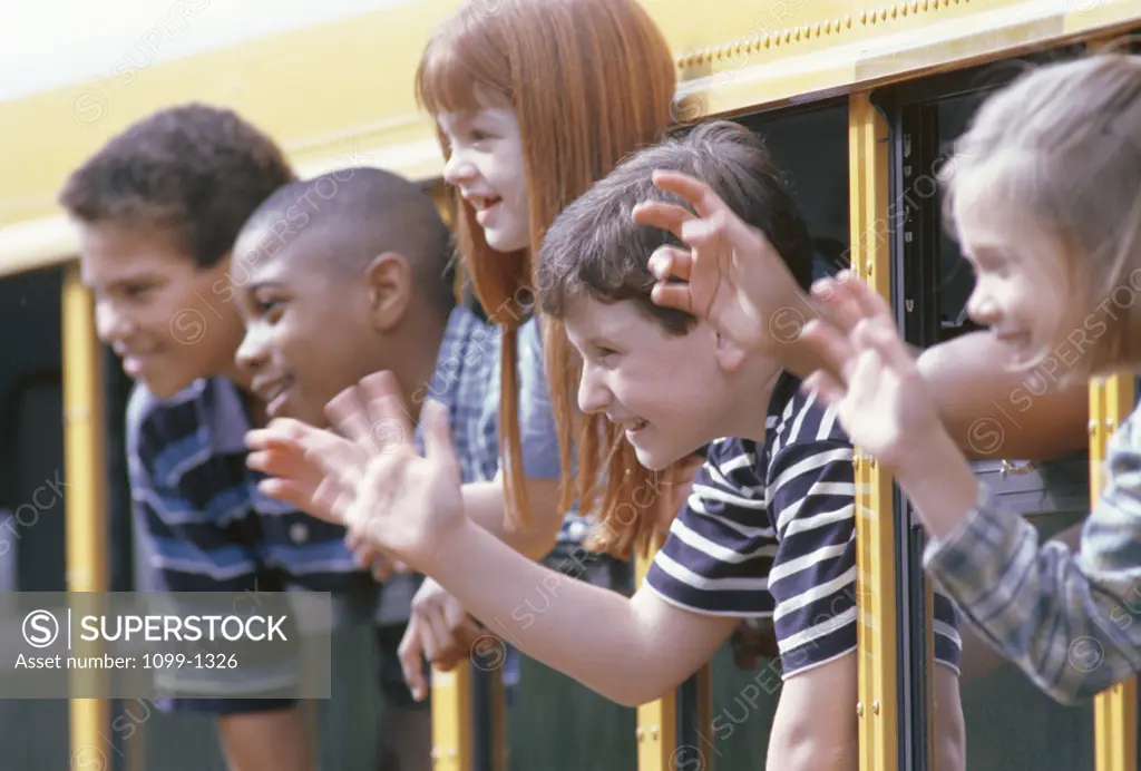 Group of children looking through the windows of a school bus
