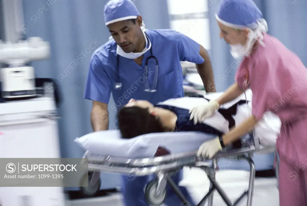 Male doctor and a female doctor pushing a patient on a stretcher