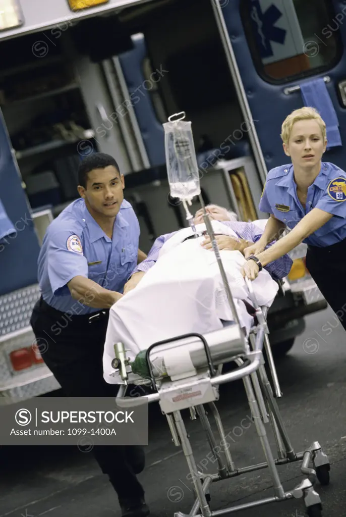 Two paramedics pushing a patient on a stretcher