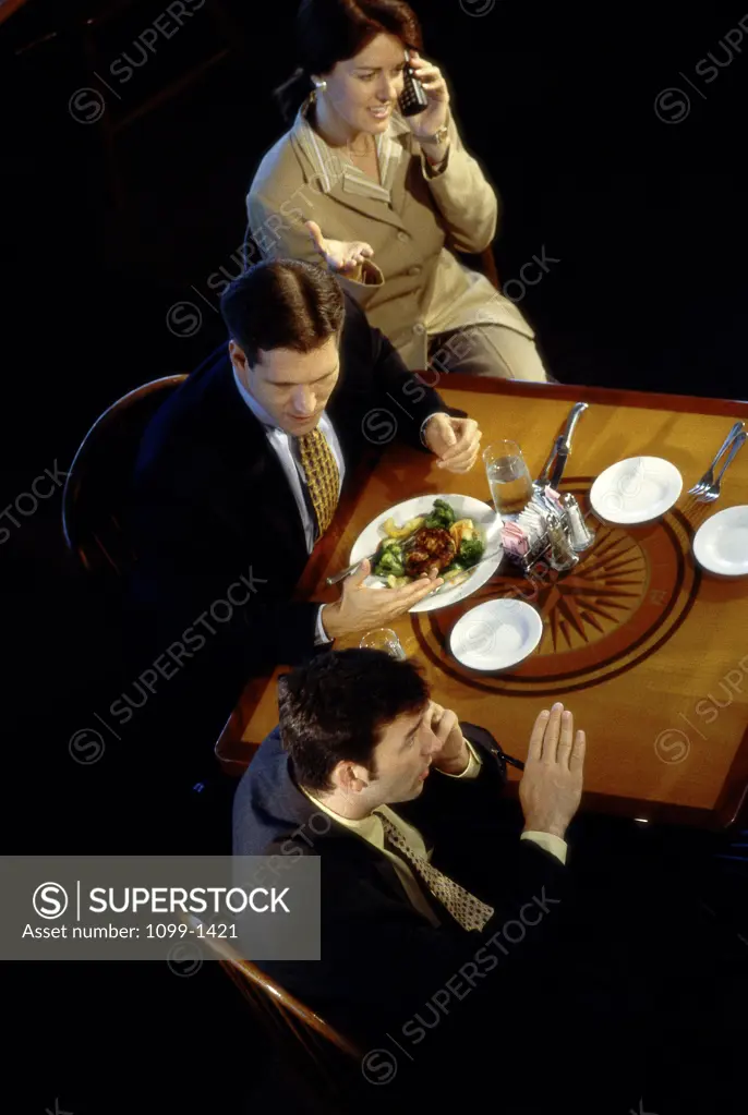 Two businessmen and a businesswoman in a restaurant