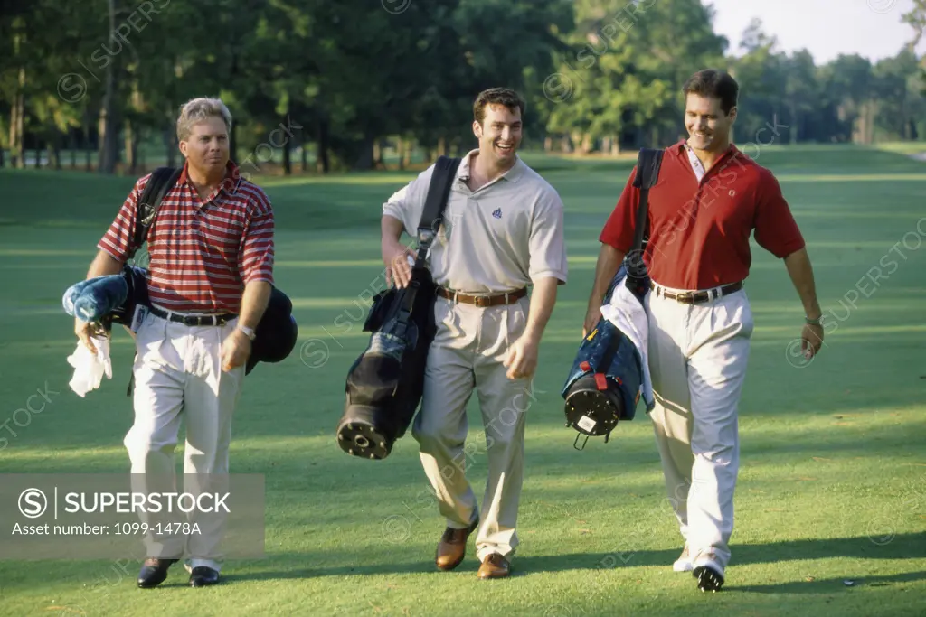 Three men walking on a golf course
