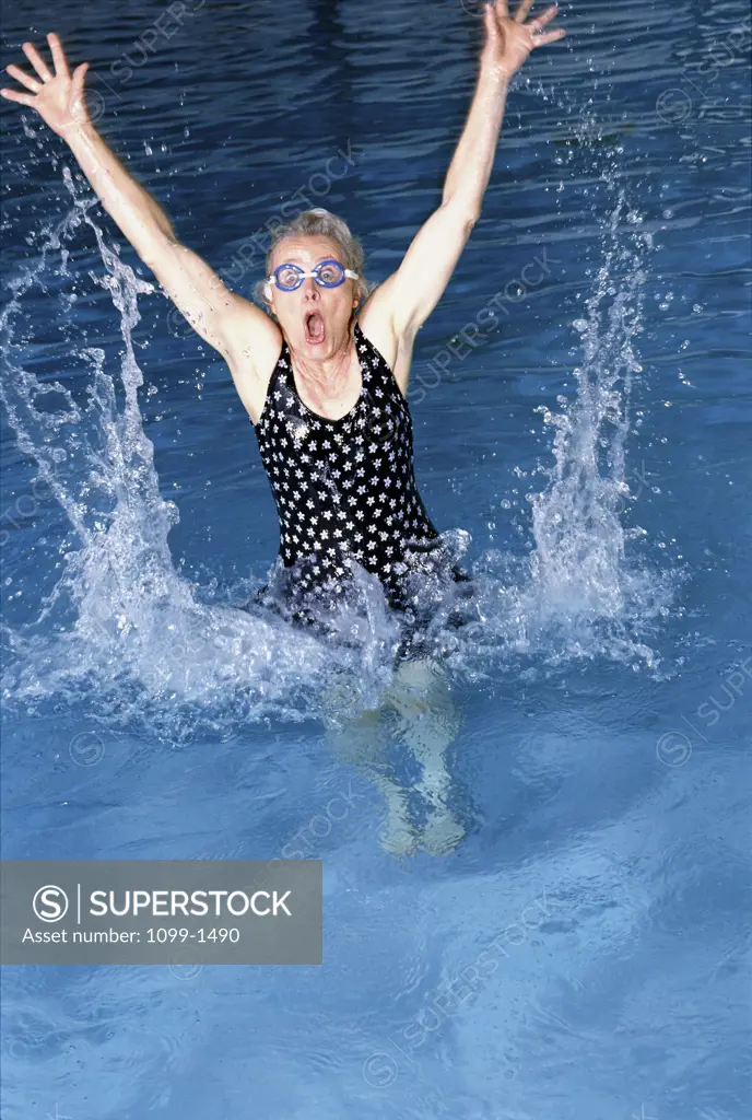 Senior woman splashing in a swimming pool