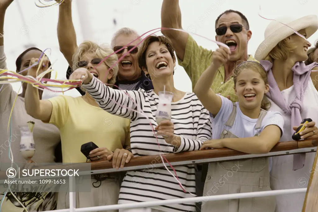 Group of people standing on a cruise ship waving