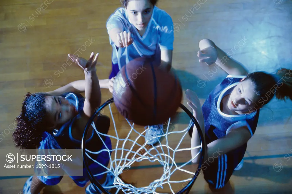 High angle view of three young women playing basketball