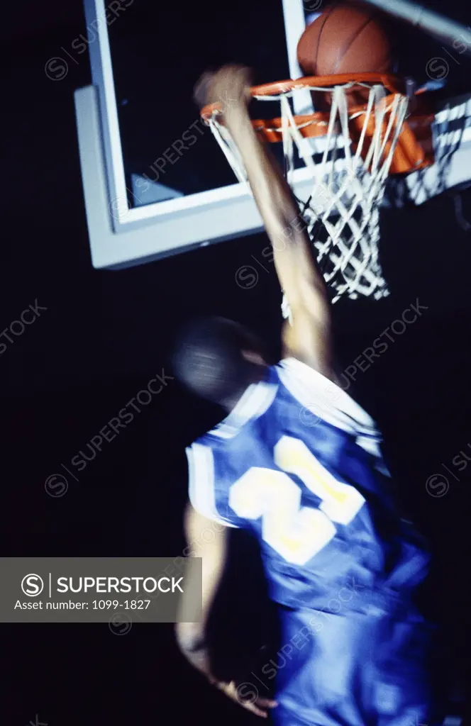 Rear view of a teenage boy playing basketball