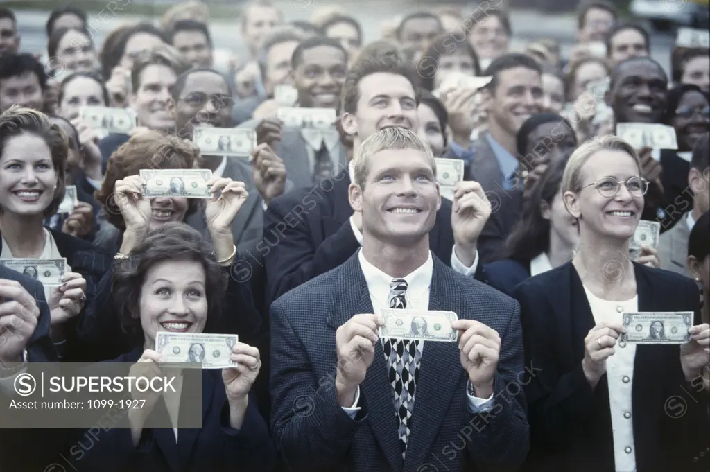 Group of business executives holding paper currency looking up