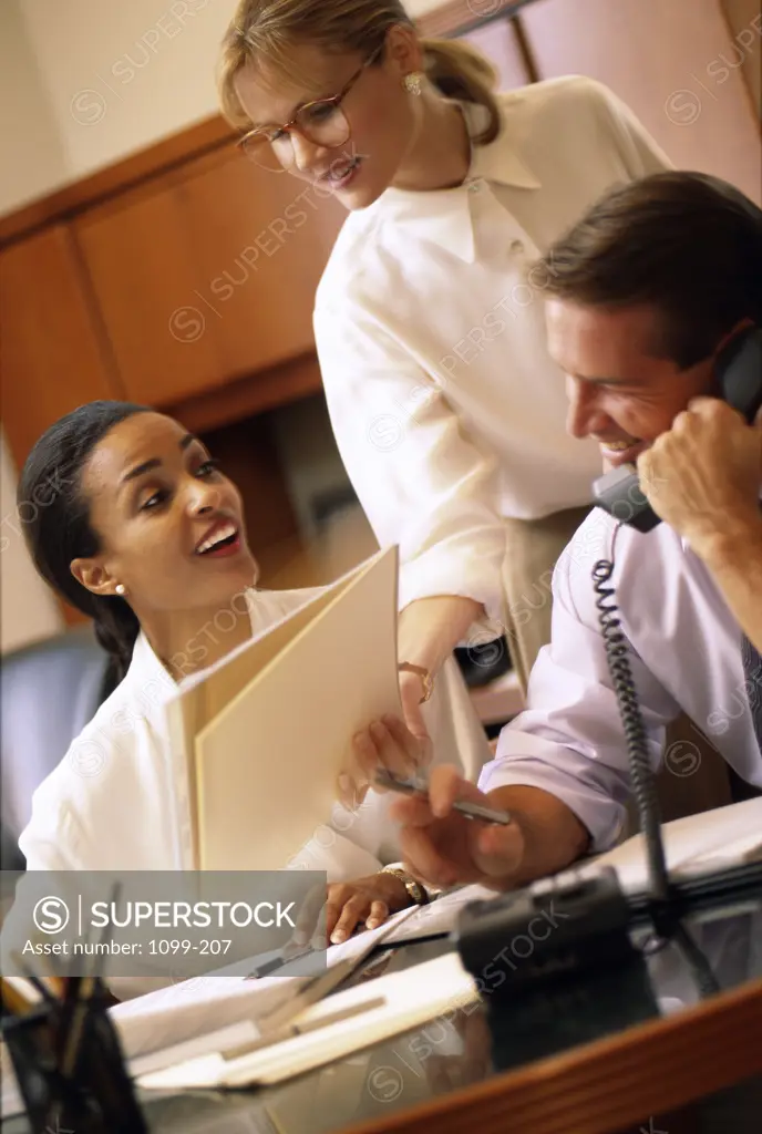 Two businesswomen and a businessman in an office