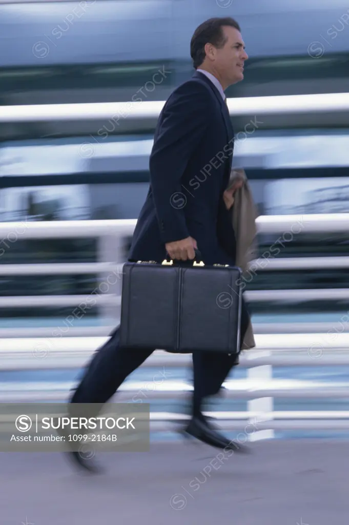 Side profile of a businessman running with a briefcase