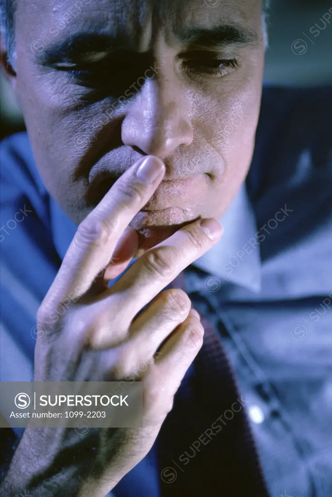 Close-up of a businessman with his fingers on his lips
