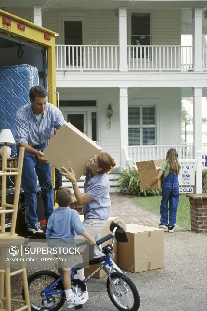 Family unloading boxes from a moving van