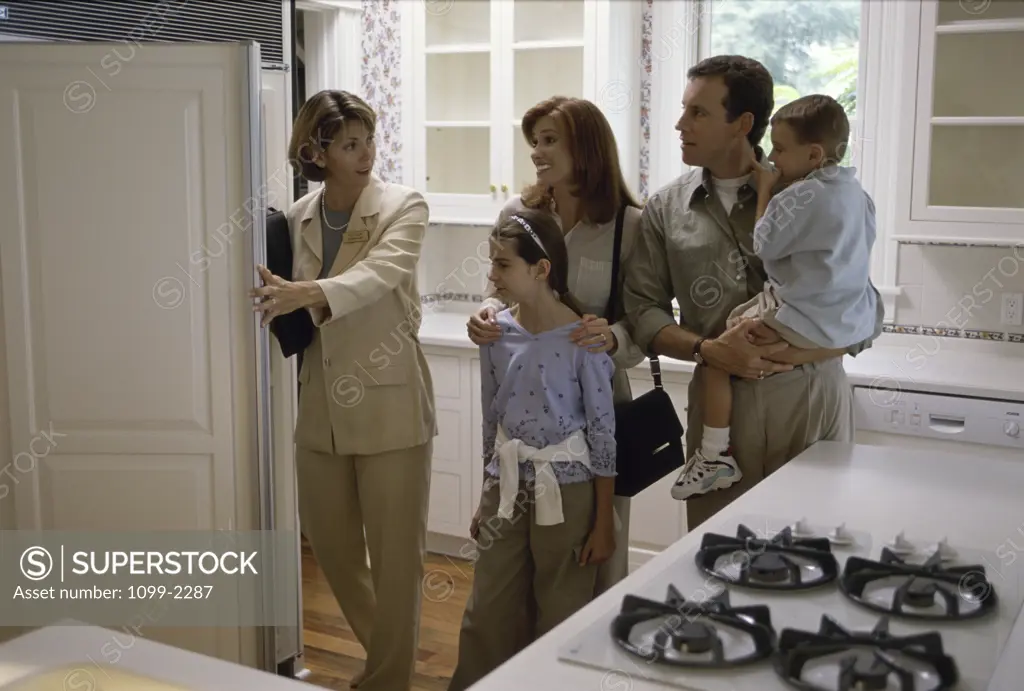 Real estate agent showing a house to a family