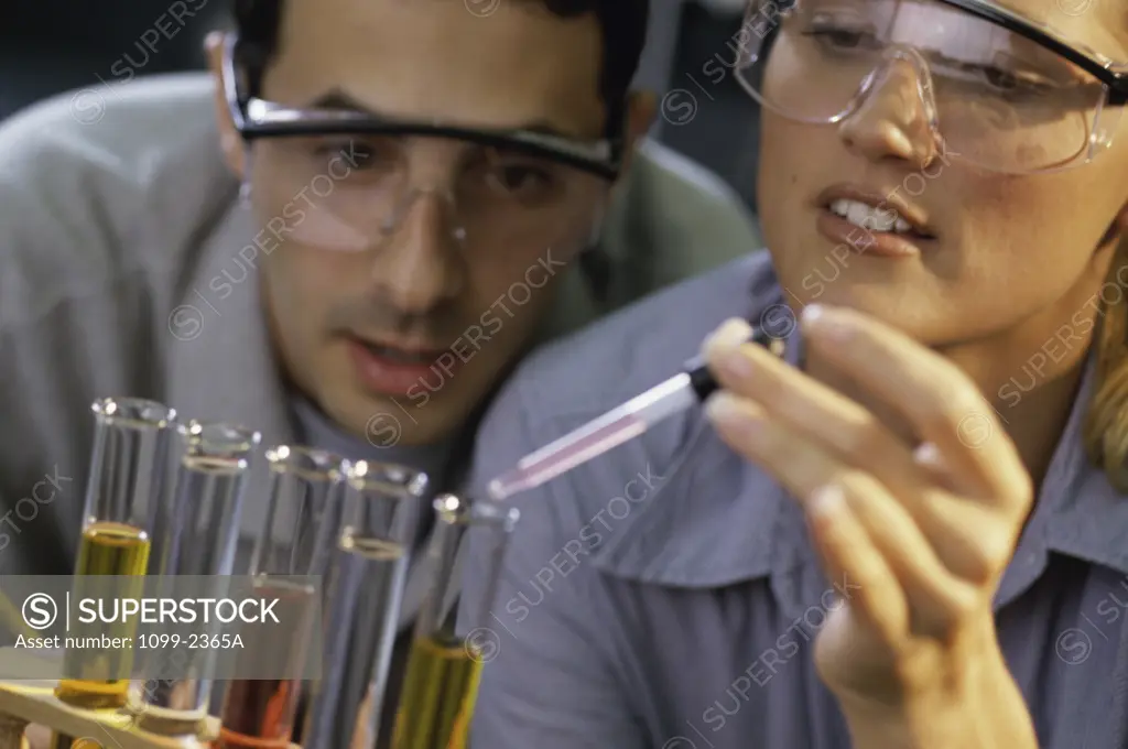 Young man and a young woman looking at test tubes in a laboratory