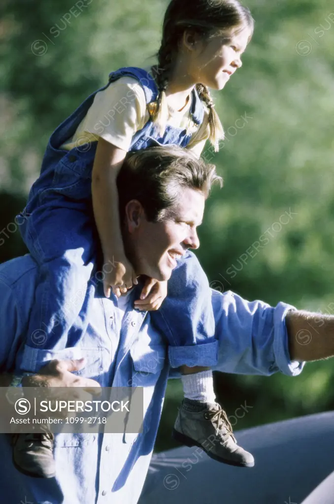 Father carrying his daughter on his shoulders