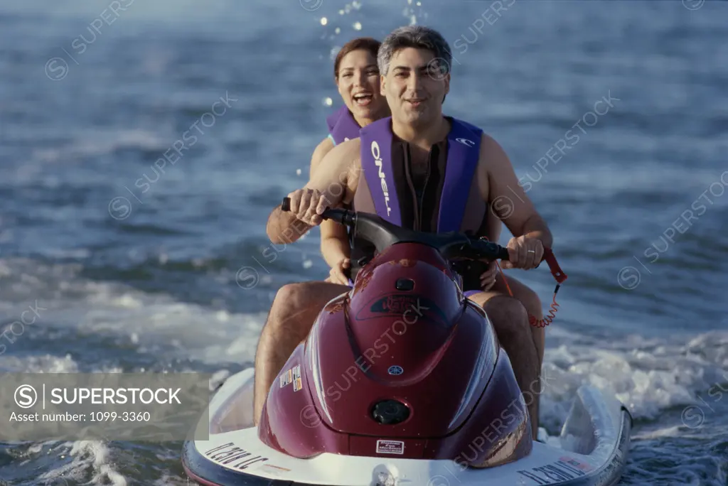 A couple riding a jet ski in the sea