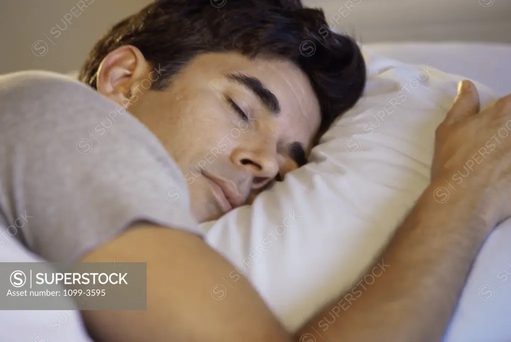 Close-up of a mid adult man sleeping on a bed
