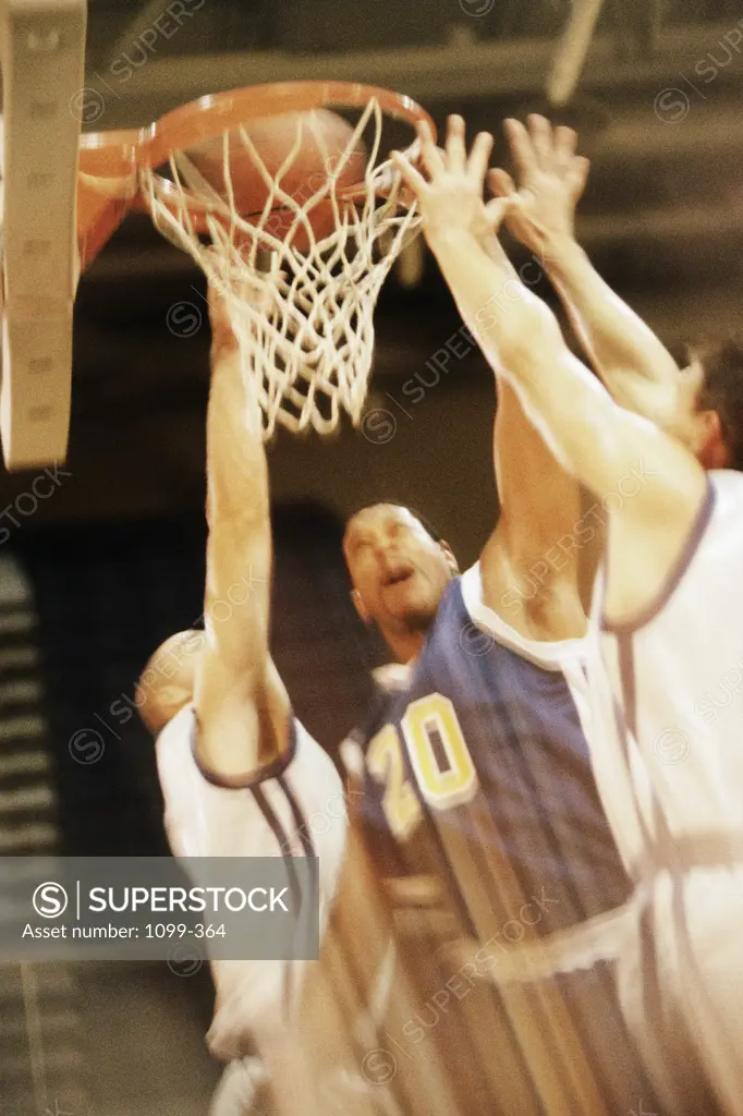 Close-up of three men playing basketball