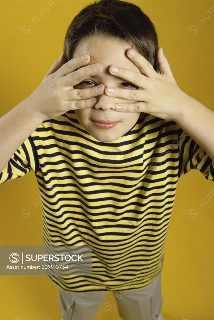 Close-up of a boy peeking through his fingers