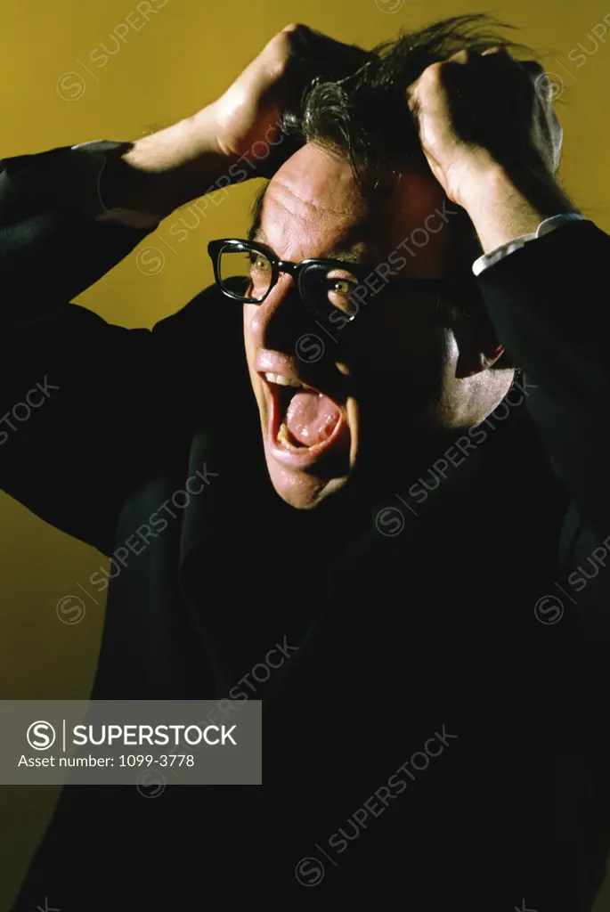 Businessman pulling his hair with his mouth open