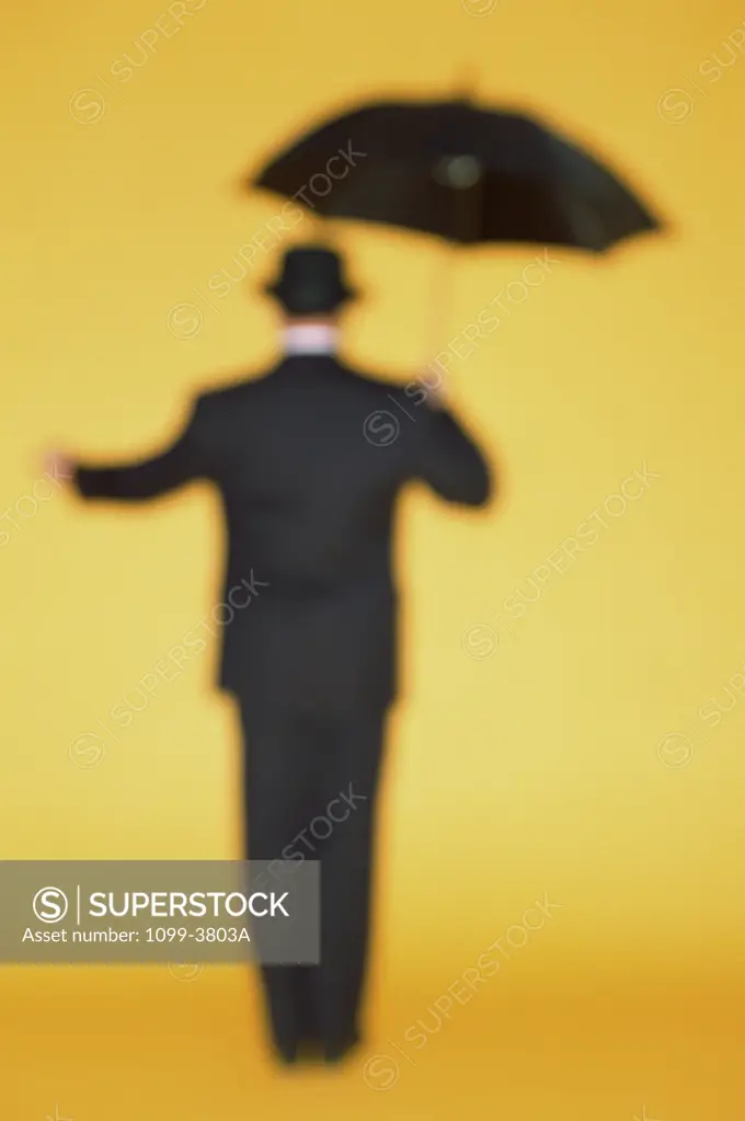 Rear view of a businessman holding an umbrella
