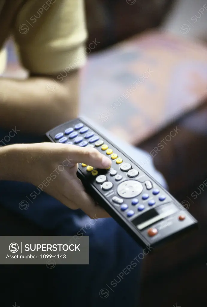 Close-up of teenage boy holding a television remote control