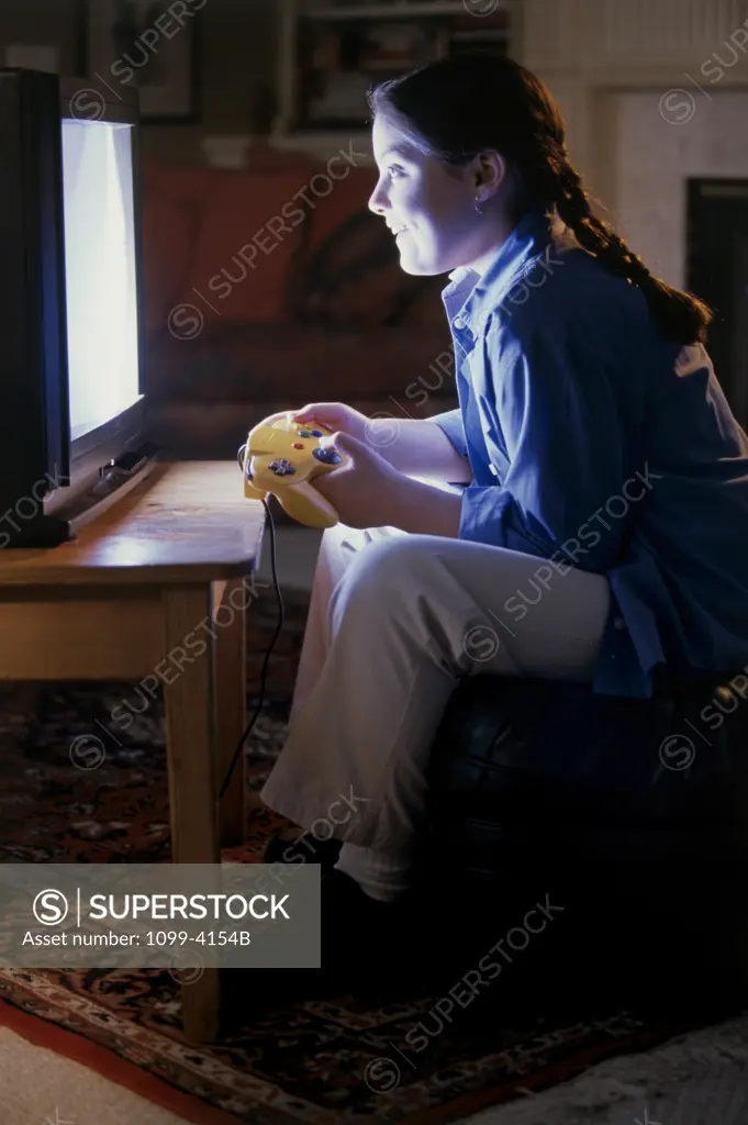 Side profile of a teenage girl playing a video game