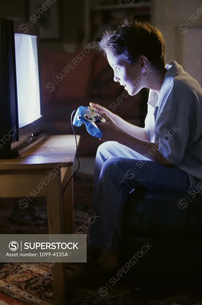 Side profile of a teenage boy playing video games