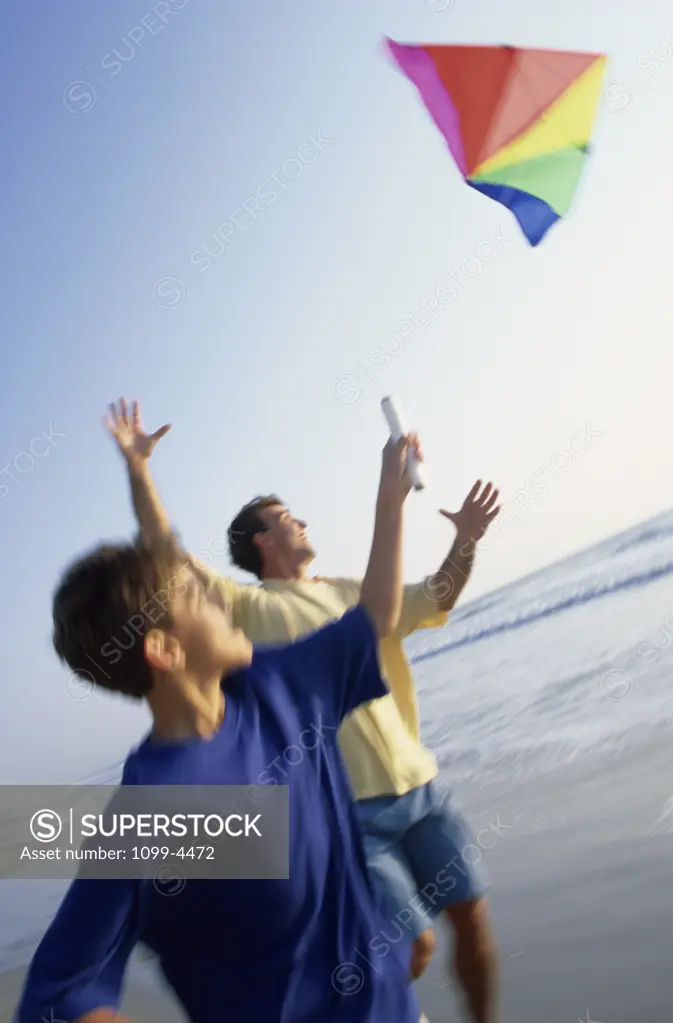 Father and his son flying a kite on the beach